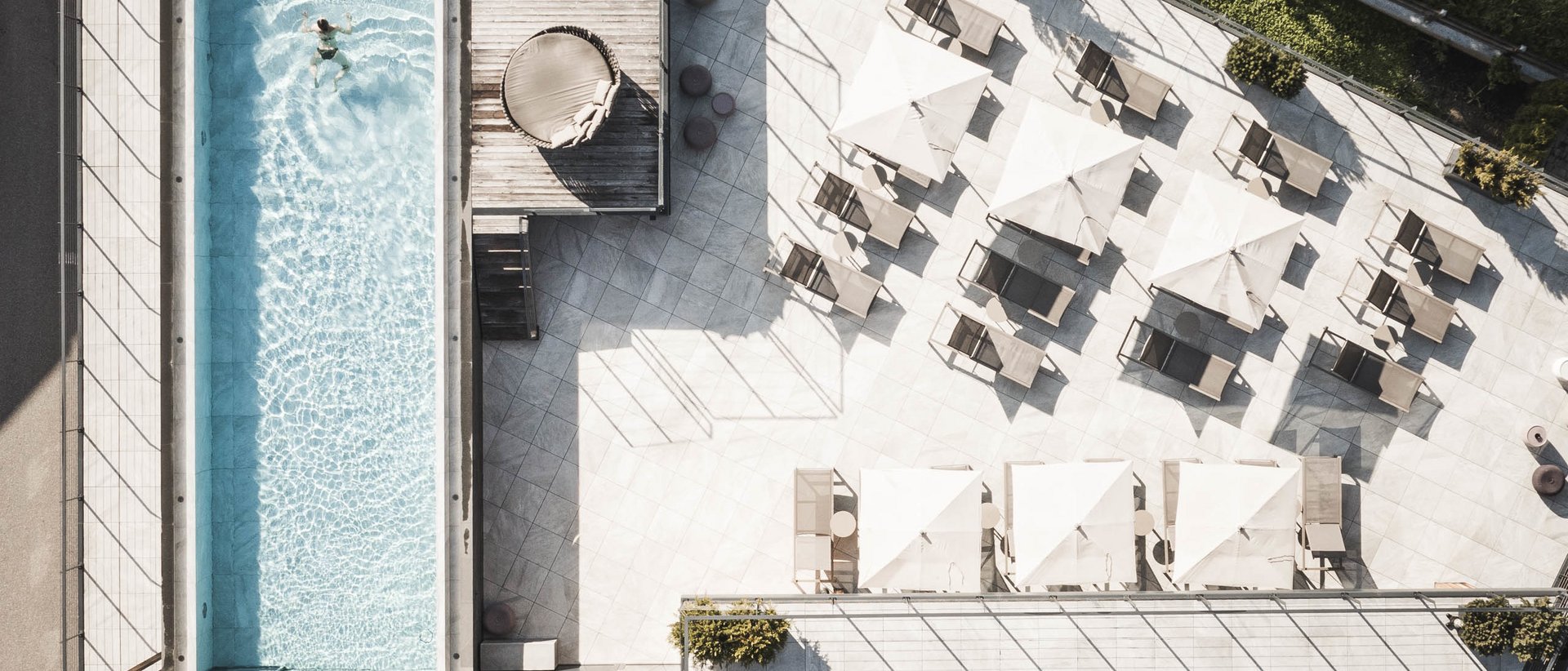 Sky Spa Adults Only Pool with one person, lounge chairs, and umbrellas on the terrace