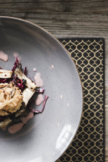 Molto più di un hotel a San Vigilio di Marebbe! Piatto gourmet creativo con funghi e salsa in ciotola grigia