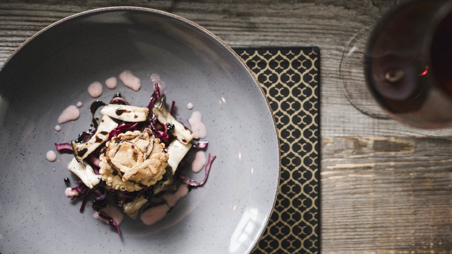 Excelsior: Wanderhotel in den Dolomiten Kreativ angerichtetes Gourmetgericht mit Pilzen und Sauce in grauer Schüssel
