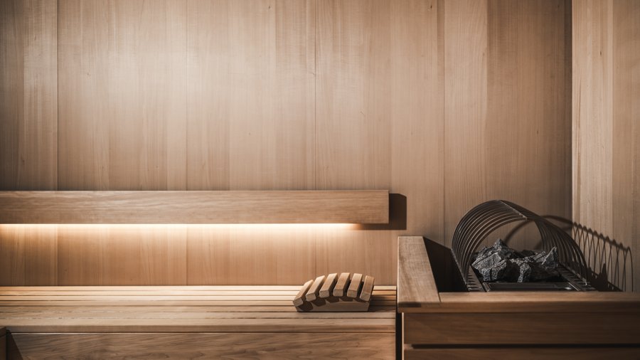 Wellnesshotel in den Dolomiten Moderner Innenraum einer Holzsauna mit Saunaofen und Kopfstütze