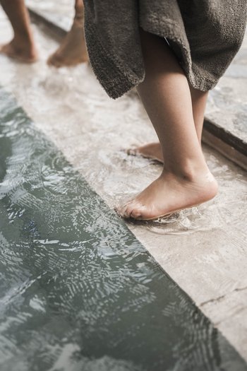 Family-friendly hotel in South Tyrol Children wading barefoot at the pool edge in shallow water