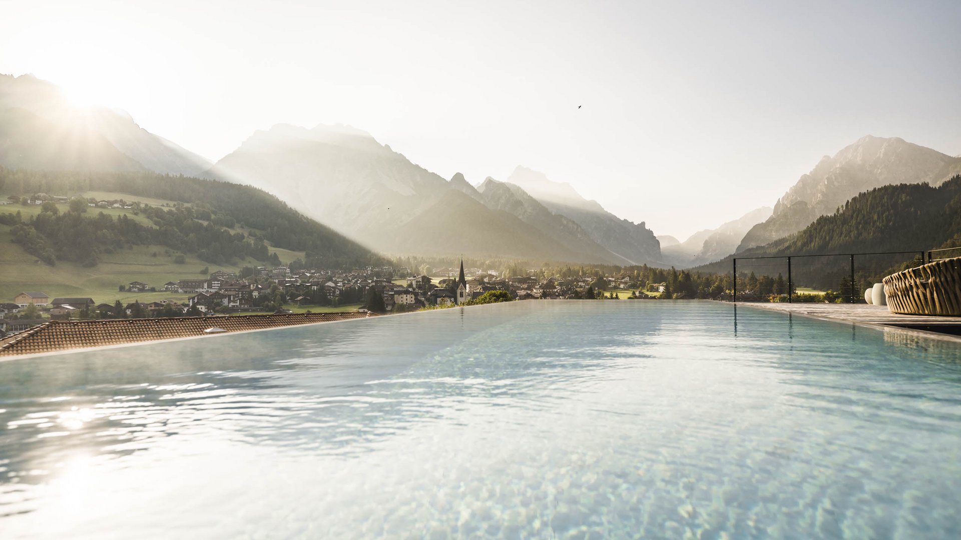 Vacanze sostenibili in Alto Adige? Excelsior! Alba su villaggio di montagna e piscina a sfioro nelle Alpi
