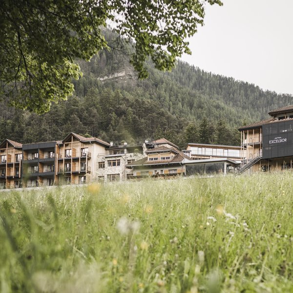 A San Vigilio di Marebbe: un hotel da sogno Hotel Excelsior circondato da prato e montagne sullo sfondo