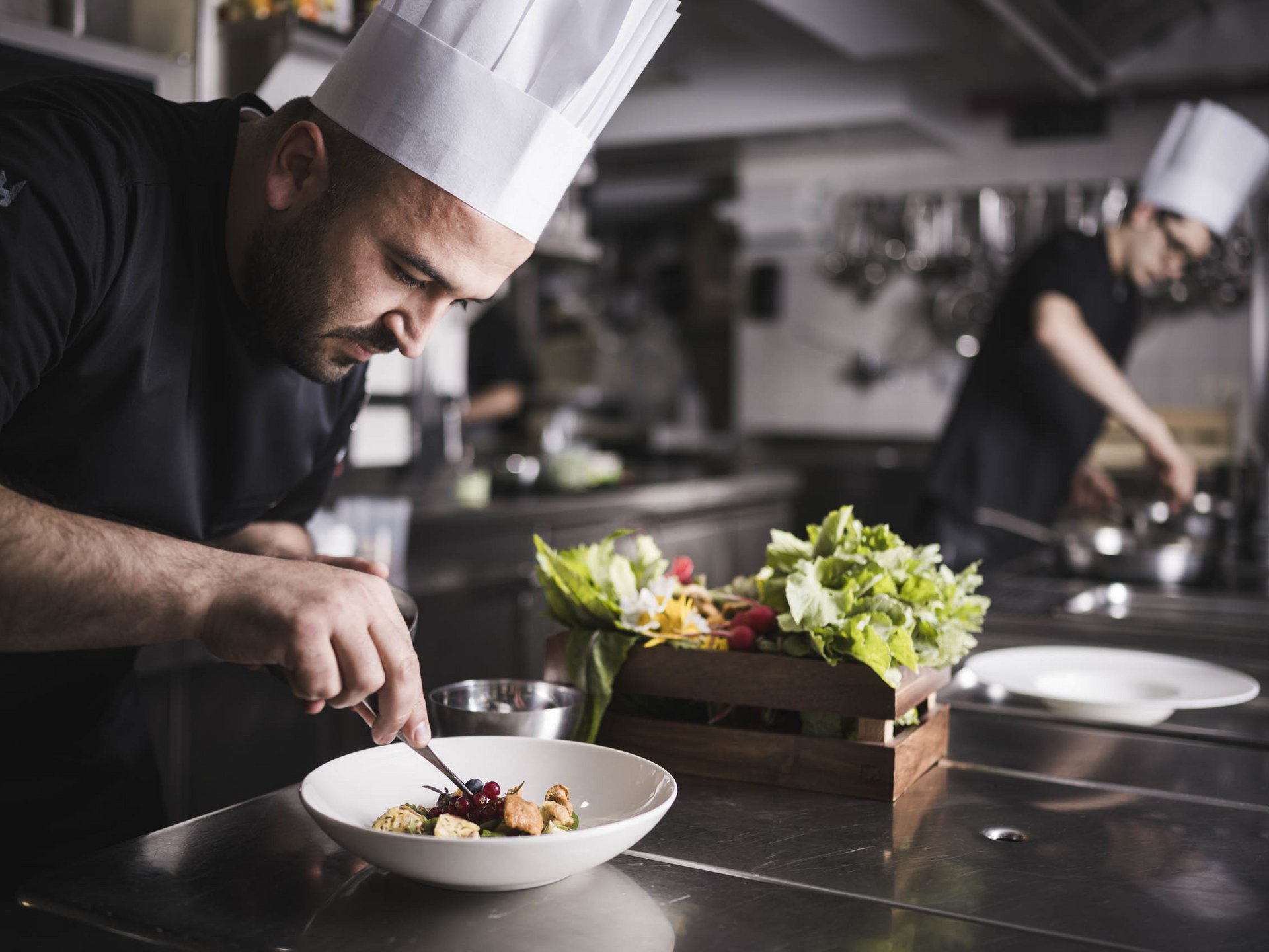 Hotel per celiaci Cuoco che decora un piatto in una cucina professionale