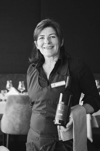 Your hotel in St. Vigil in Enneberg!! Waitress holding a wine bottle in an elegant restaurant