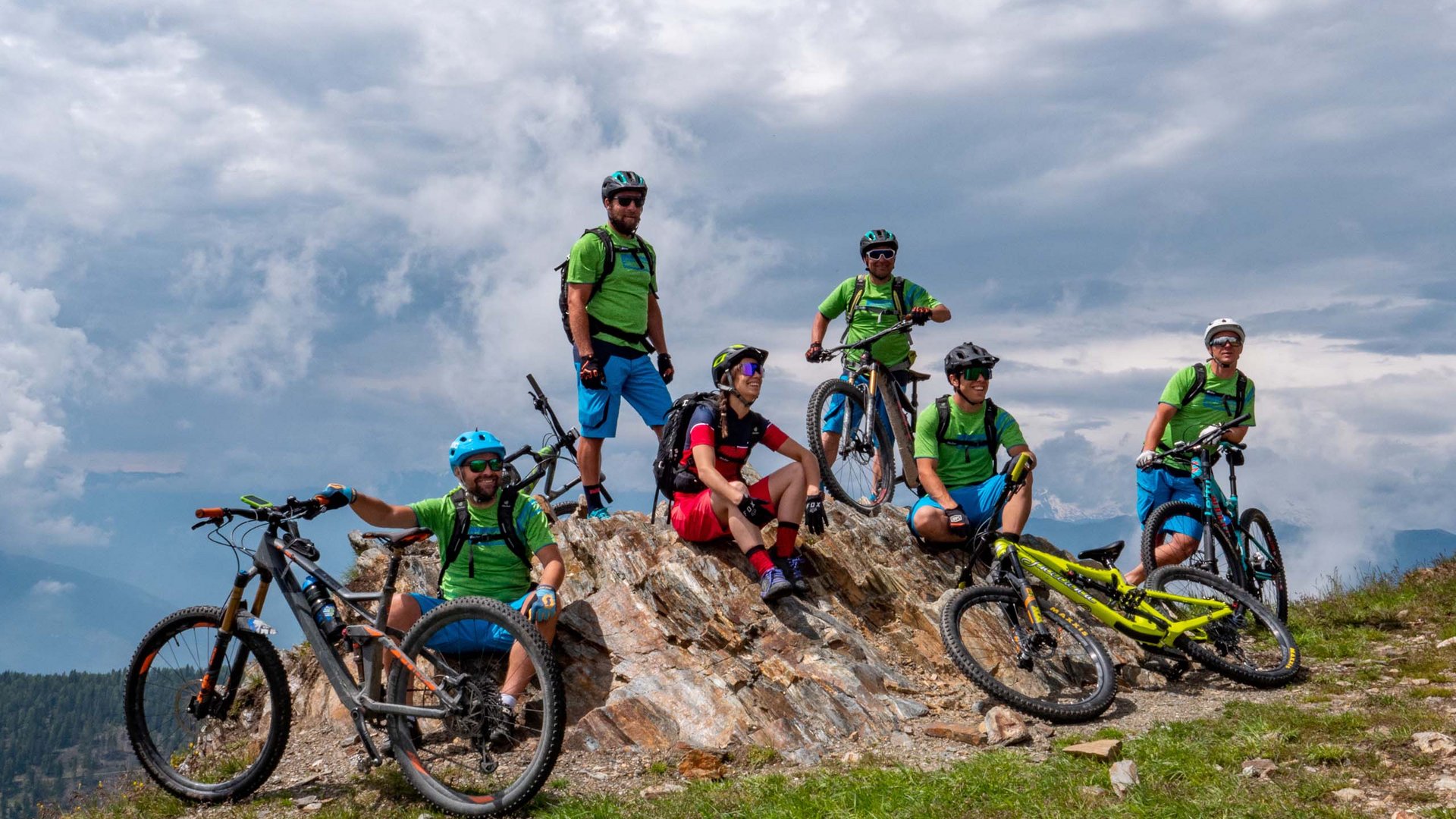 Regione bike Sei ciclisti da montagna in pausa su una roccia con bici in montagna