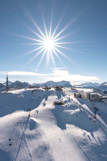 Il vostro sport hotel a San Vigilio di Marebbe Cima della montagna innevata con sole splendente e impianti di risalita
