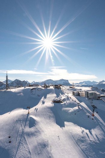 Il vostro sport hotel a San Vigilio di Marebbe Cima della montagna innevata con sole splendente e impianti di risalita