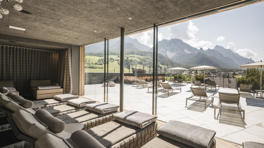 kurzurlaub-suedtirol Entspannungsbereich mit Liegestühlen und Blick auf Berge bei Sonnenlicht