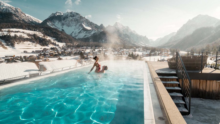 Excelsior: un hotel romantico in Alto Adige Coppia in piscina riscaldata all'aperto con montagne innevate sullo sfondo
