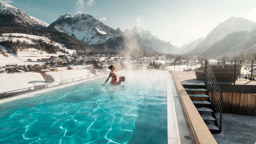 Excelsior: un hotel romantico in Alto Adige Coppia in piscina riscaldata all'aperto con montagne innevate sullo sfondo