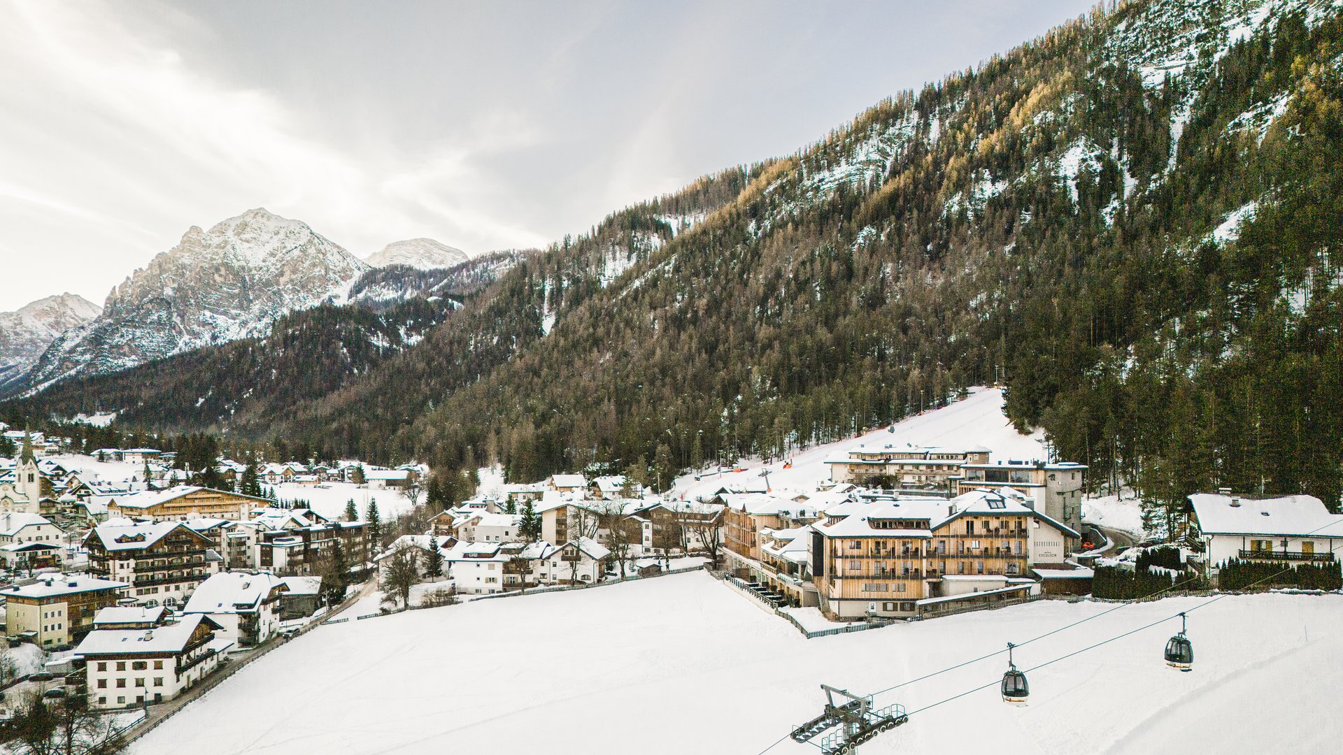 Il vostro sport hotel a San Vigilio di Marebbe Villaggio invernale con cabinovie davanti a montagne innevate e foreste