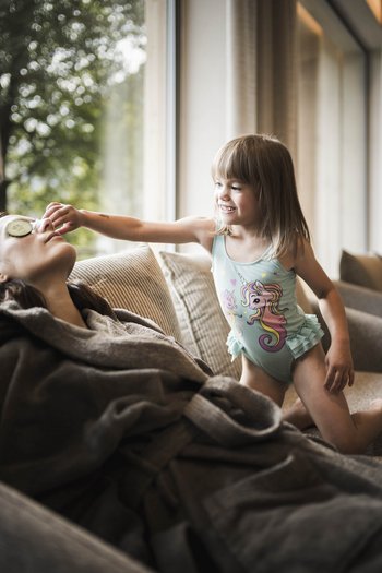 Hotel con infinity pool in Alto Adige: l’Excelsior Bambina mette fettina di cetriolo sugli occhi della madre mentre si rilassano sul divano