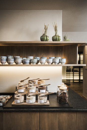 Our news 2024 Shelves with bowls, cereals, and cookies in glass jars in a modern setting