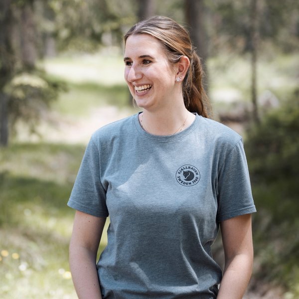 Wellnesshotel in Südtirol: Auf in den Traumurlaub! Lächelnde Frau in grauem Fjällräven T-Shirt im Wald