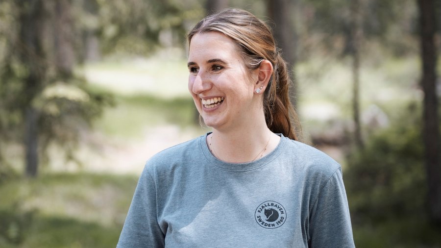 A San Vigilio di Marebbe: un hotel da sogno Donna sorridente con maglietta grigia Fjällräven in un bosco