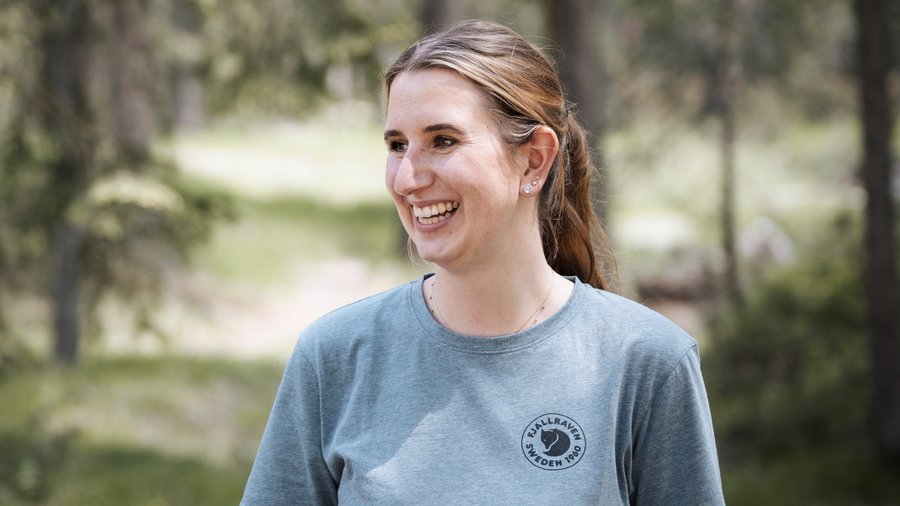 Dolomites hotel for mountain people Smiling woman wearing grey Fjällräven T-shirt in forest