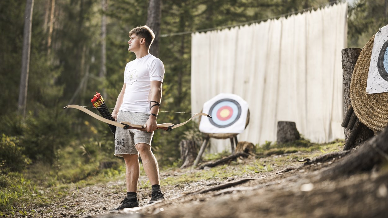 #myexcelsior Sunday News 16.03.2025 Mann mit Bogen und Pfeilen steht vor Zielscheiben im Wald