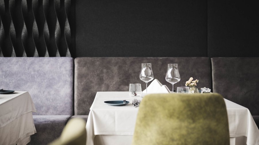 Excelsior: un hotel romantico in Alto Adige Tavolo apparecchiato elegante in un ristorante moderno con bicchieri da vino e acqua