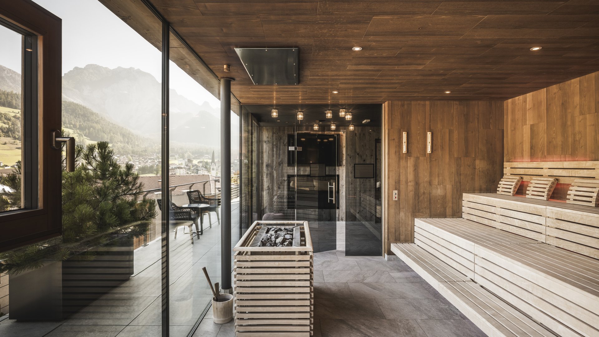 Hotel adults only in Alto Adige: l’Excelsior! Area sauna moderna con parete di vetro e vista sulle montagne
