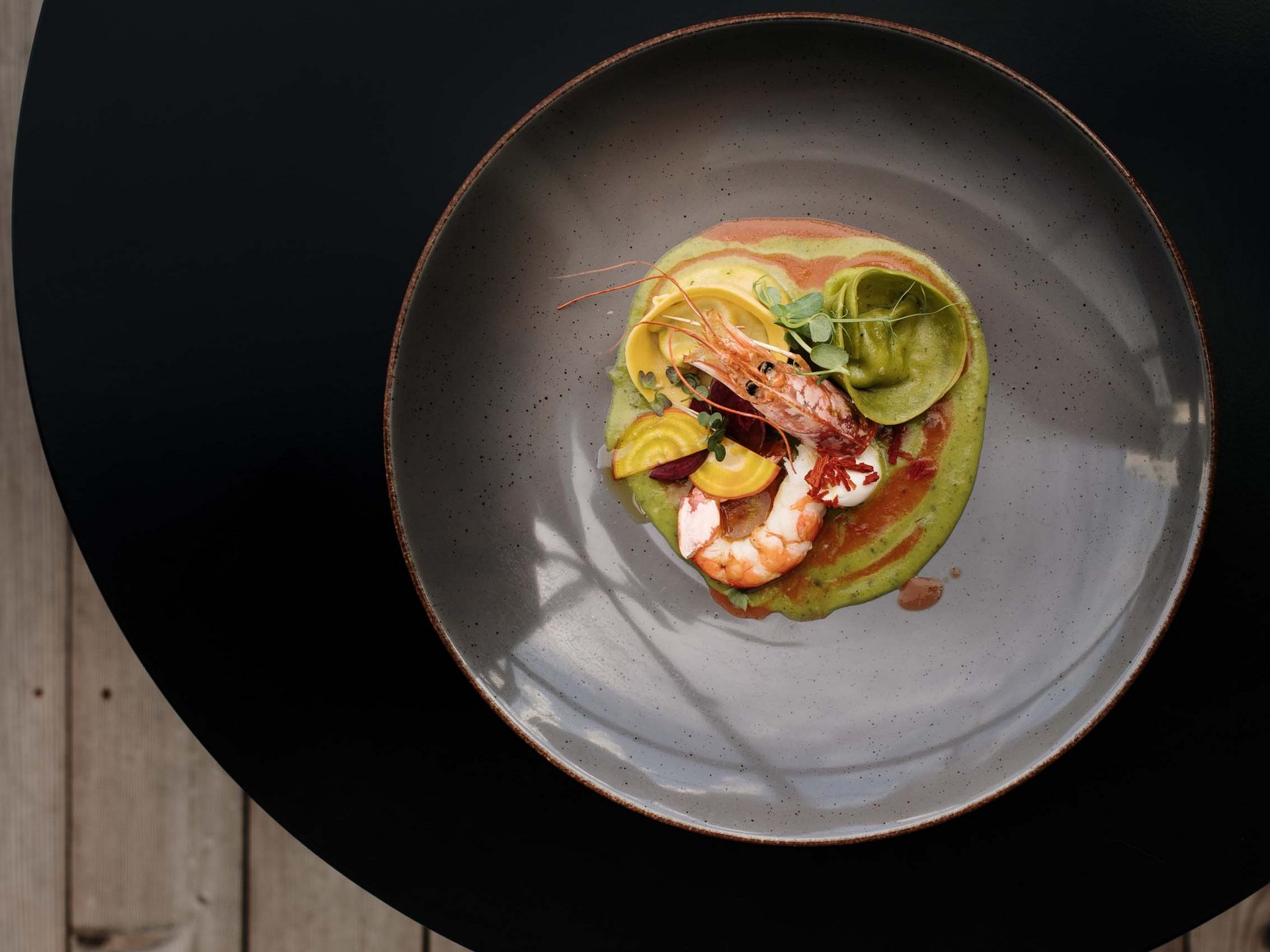 Hotel per celiaci Gamberi con salsa verde e pasta ripiena su piatto grigio