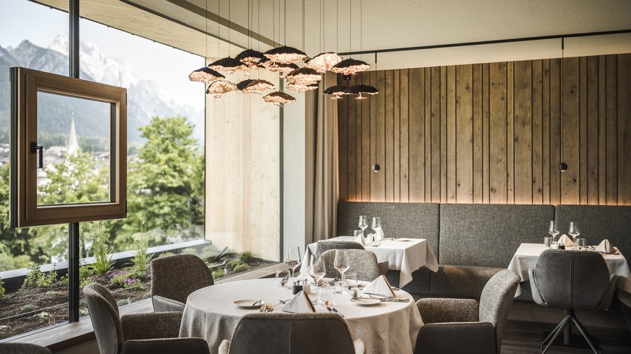 Wellness hotel in the Dolomites Modern restaurant with panoramic window and mountain view