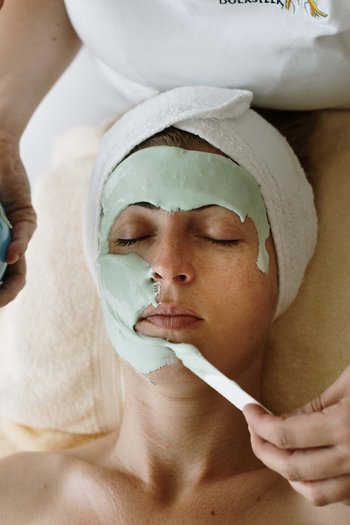 Wellness hotel in South Tyrol | Dolomites Woman receiving facial mask during spa treatment