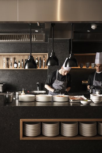 Le nostre novità 2024 Due cuochi preparano cibo in una cucina di ristorante moderna