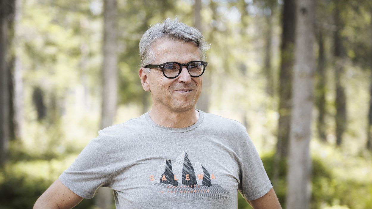 Excelsior: Wanderhotel in den Dolomiten Mann mit grauem T-Shirt und Brille steht im Wald