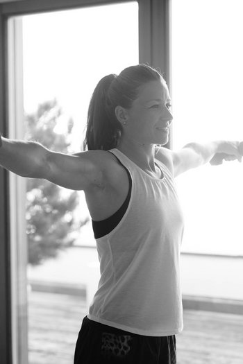 Ihr Hotel in St. Vigil in Enneberg! Frau macht seitliche Armheben mit Hanteln vor großem Fenster