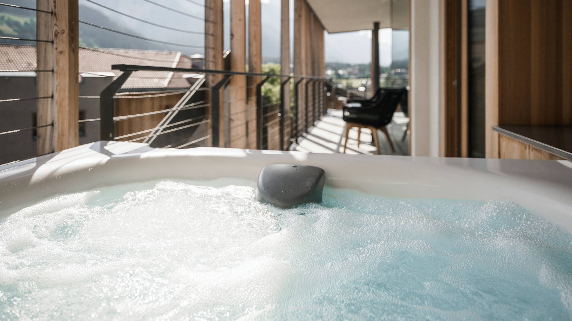 Sprudelndes Outdoor-Whirlpool auf Balkon mit Bergblick