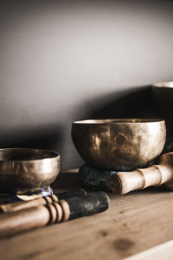 Hotel in the Dolomites for adults only Three Tibetan singing bowls with mallets on wooden table