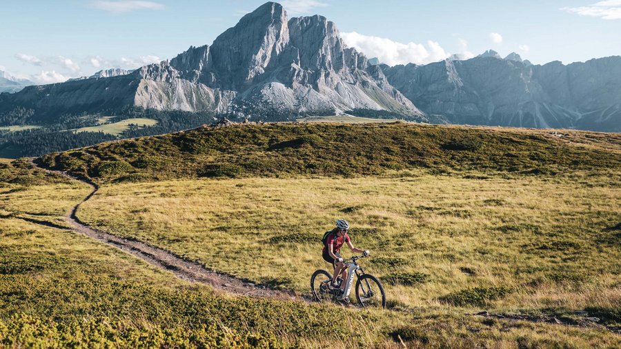 Regione bike Ciclista su un sentiero in un paesaggio montano alpino soleggiato