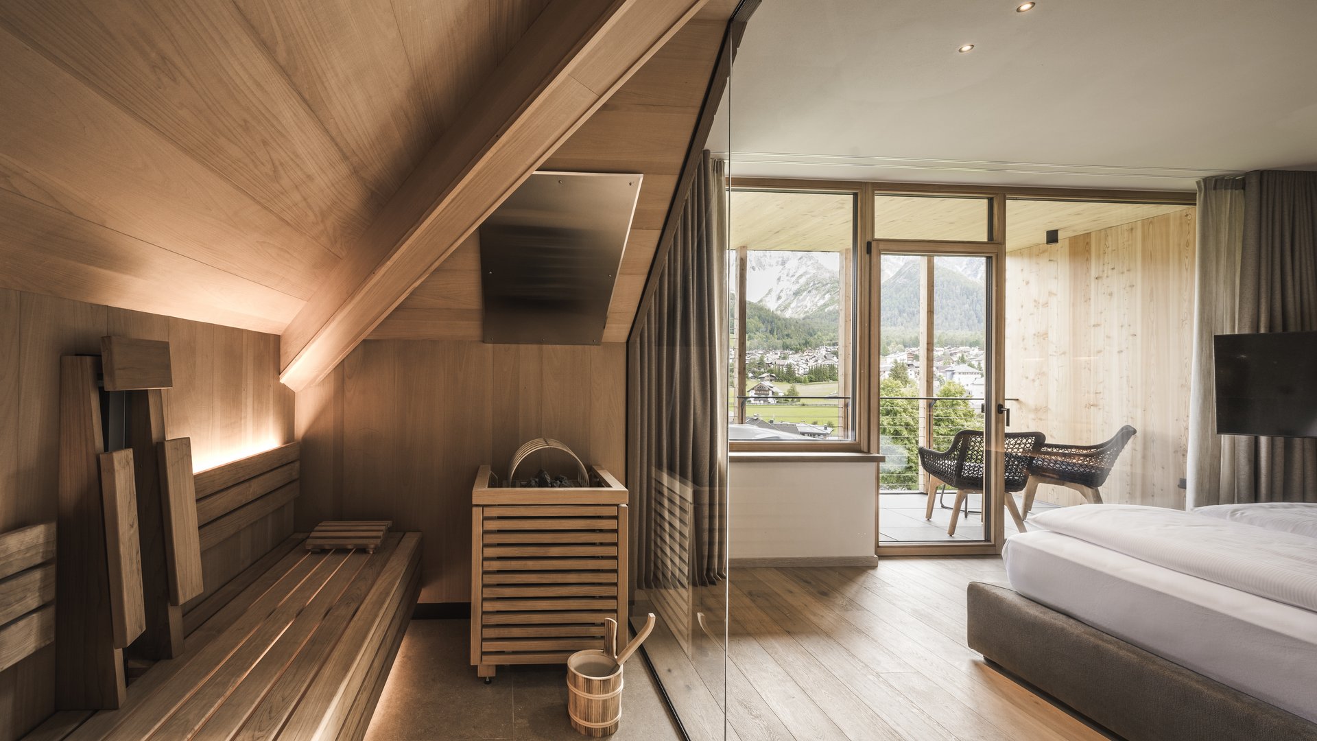 Wohnen am Kronplatz: Hotel an der Piste Moderner Saunabereich neben Schlafzimmer mit Balkon und Bergblick