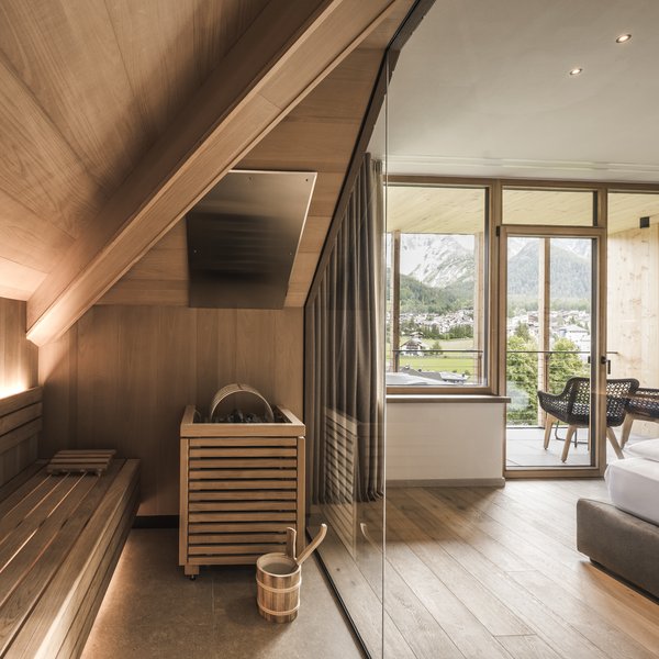 Wellnesshotel in Südtirol: Auf in den Traumurlaub! Moderner Saunabereich neben Schlafzimmer mit Balkon und Bergblick