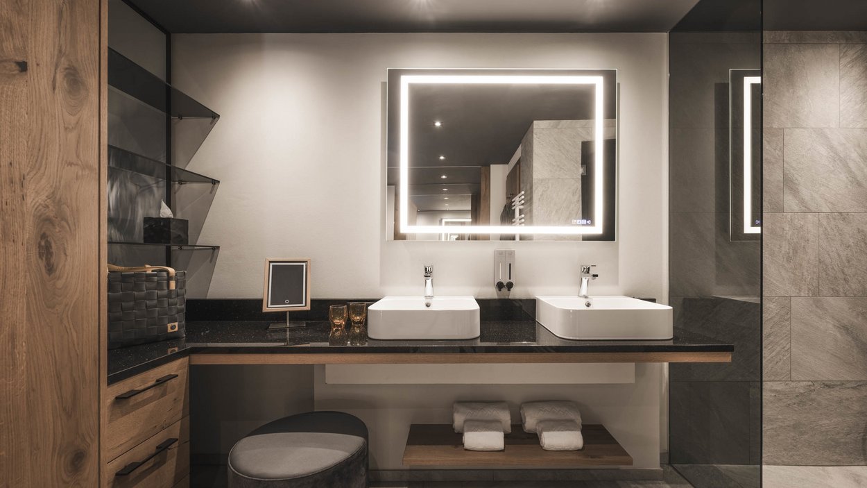 Sustainable hotels in South Tyrol? The Excelsior! Modern bathroom with double sinks and illuminated mirror