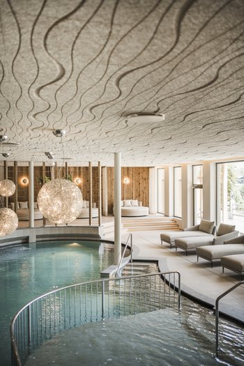 Family-friendly hotel in South Tyrol Modern indoor pool with lounge areas and decorative spherical lights
