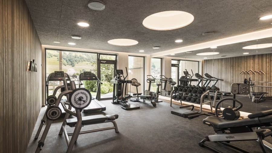 Wellness hotel in the Dolomites Modern gym room with exercise equipment and large windows