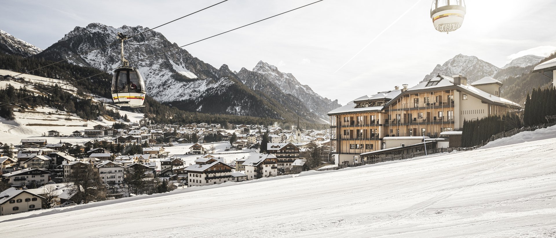 #myexcelsior Sunday News 16.03.2025 Cabine della funivia sopra una località sciistica innevata con montagne sullo sfondo