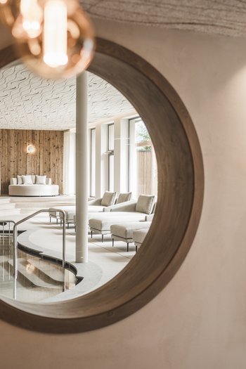 Hotel con infinity pool in Alto Adige: l’Excelsior Specchio riflette area spa con piscina e comode sedute moderne