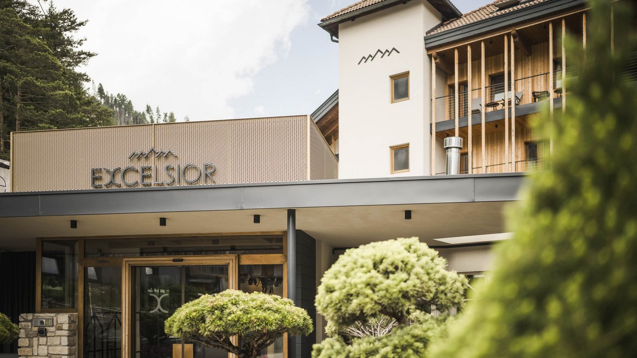 #myexcelsior Sunday News 01.03.2026 Eingang des Hotels Excelsior mit dekorativen Bäumen und modernen Fassaden