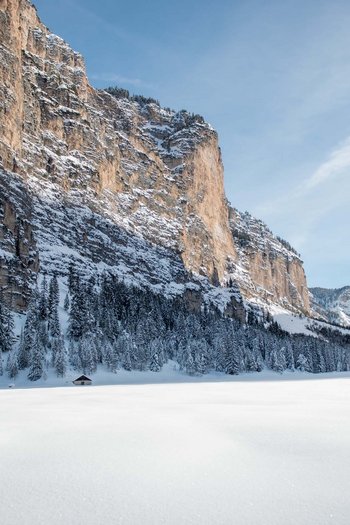 Il vostro sport hotel a San Vigilio di Marebbe Paesaggio montano innevato con pini e baite sotto un cielo limpido