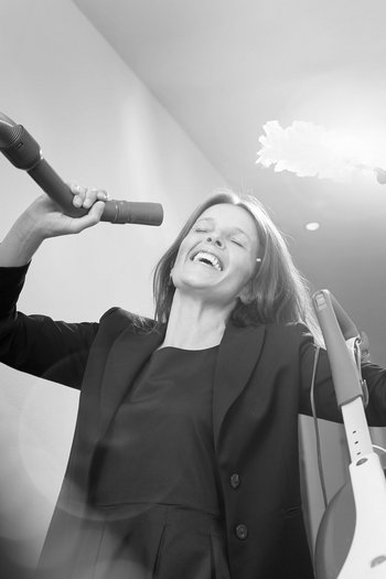 Ihr Hotel in St. Vigil in Enneberg! Frau spielt singend mit Staubsauger und Federduster im Flur