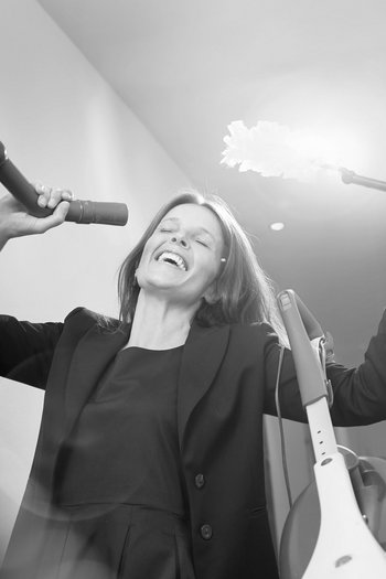 Your hotel in St. Vigil in Enneberg!! Woman singing and playing with vacuum and feather duster in hallway