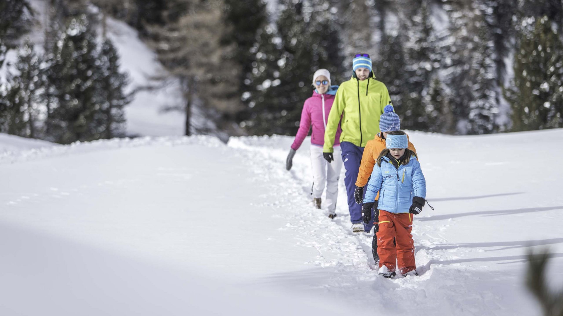 Events: Excelsior Dolomites Life Resort Family hiking in snow wearing colorful winter clothes