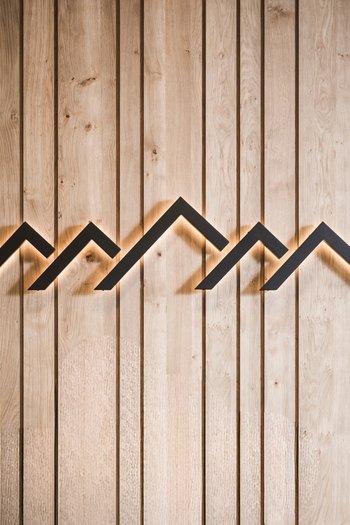 More than a hotel: Excelsior Backlit wall decor with mountain silhouettes on wooden panels