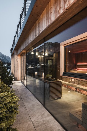 Hotel in the Dolomites for adults only Exterior of a modern sauna with mountain view at dusk