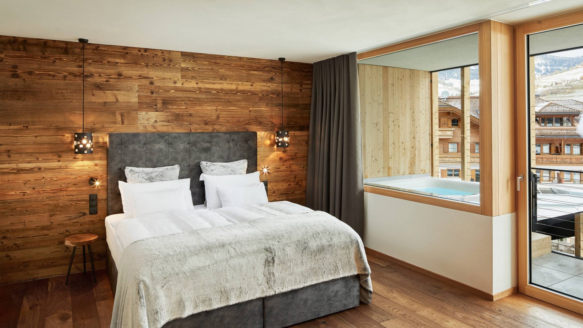 Excelsior: Ihr Hotel mit Whirlpool im Zimmer in Südtirol Gemütliches Schlafzimmer mit Holzwand und Blick auf Außenwhirlpool