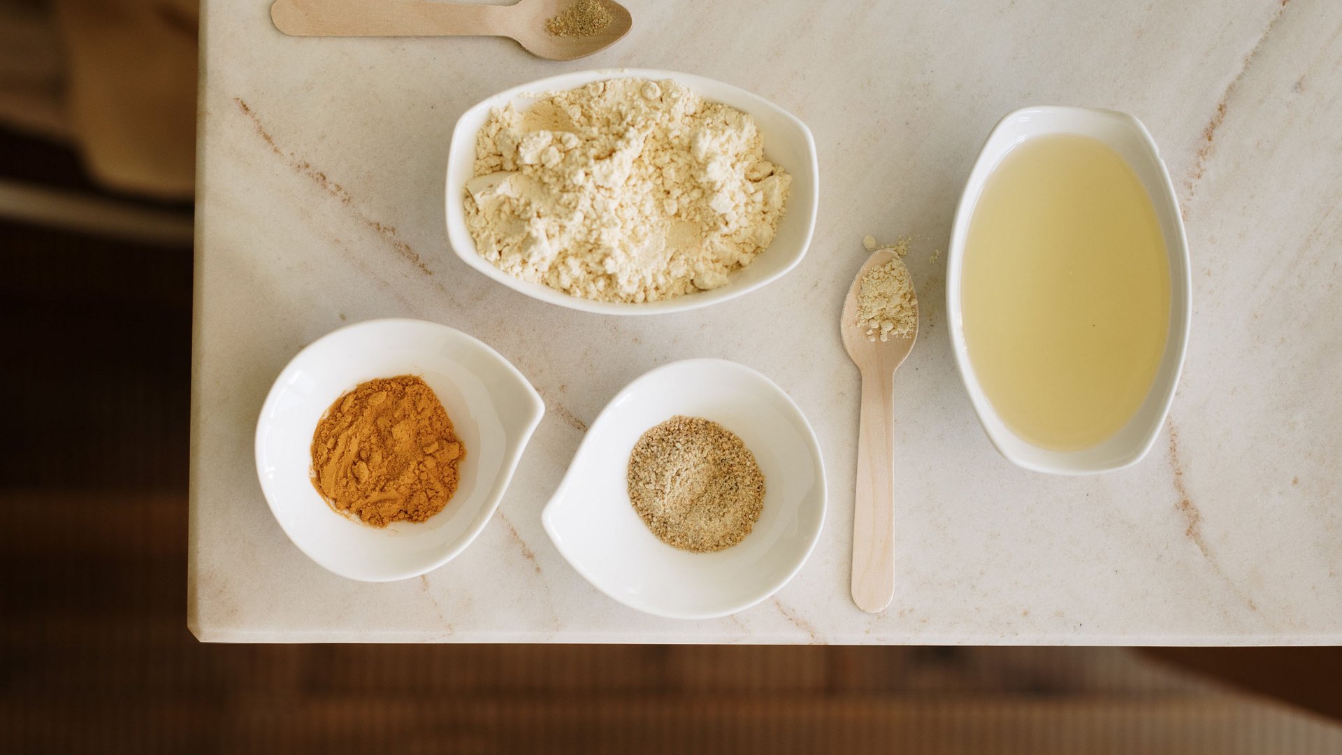 Massagen im Wellnesshotel am Kronplatz Verschiedene Gewürze und Mehl in weißen Schalen auf einem Marmortisch