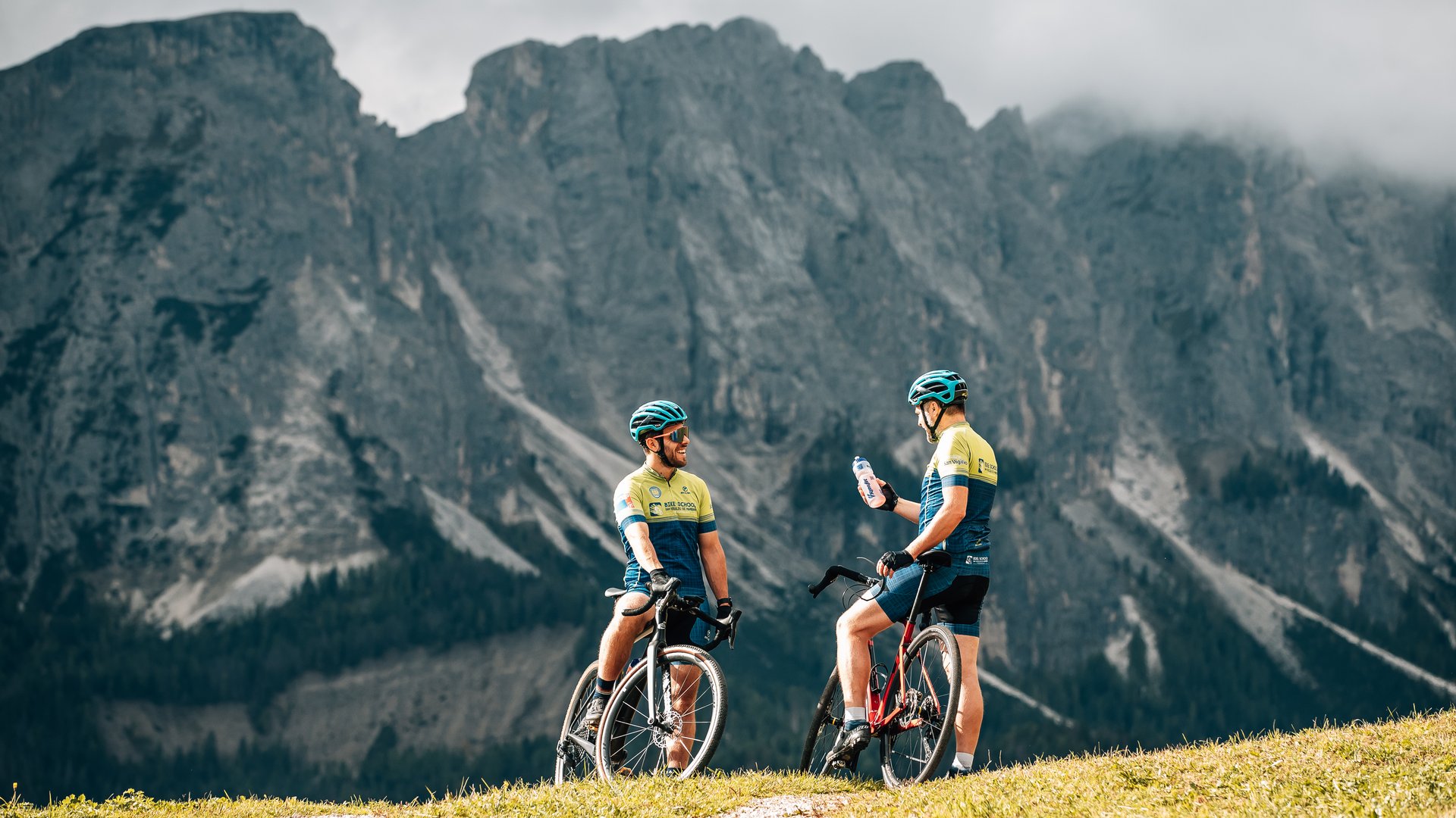 Due ciclisti fanno una pausa su un sentiero di montagna con vista panoramica